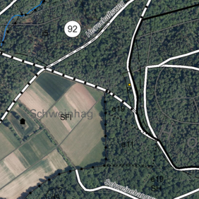 Ausschnitt eines Luftbildes, das von oben den Herrschaftsweg und den Parkplatz zeigt. Zwischen den eingezeichneten Wegen sind grüne Wald und braune Feldflächen zu erkennen.