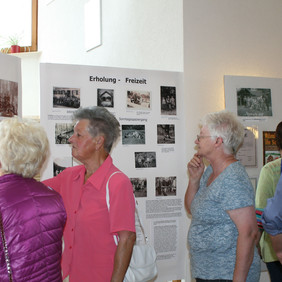 An den Stellwänden der Fotoausstellung werden Erinnerungen wach und gegenseitig ausgetauscht.