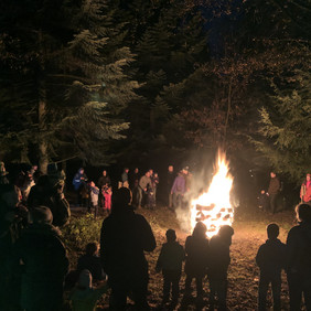 Menschen stehen im Wald um das Nikolausfeuer herum.